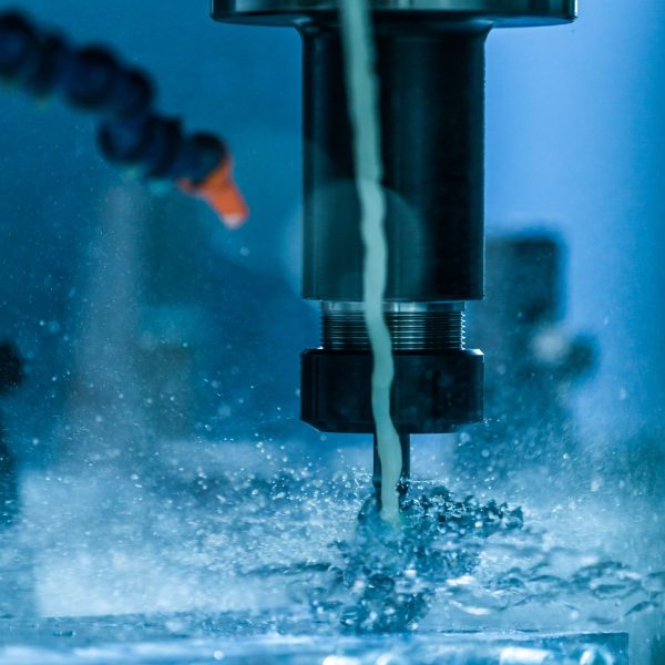 A close-up view on collet chuck and swarf wrapped over carbide drill while cnc drilling under liquid coolant. Feed and cutting speed adjusting problem. Milling machine debugging issue.